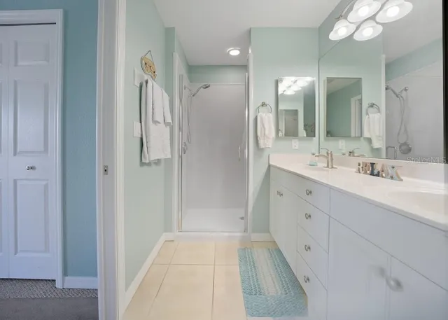 a large white bathroom with a granite countertop sink a toilet and a mirror