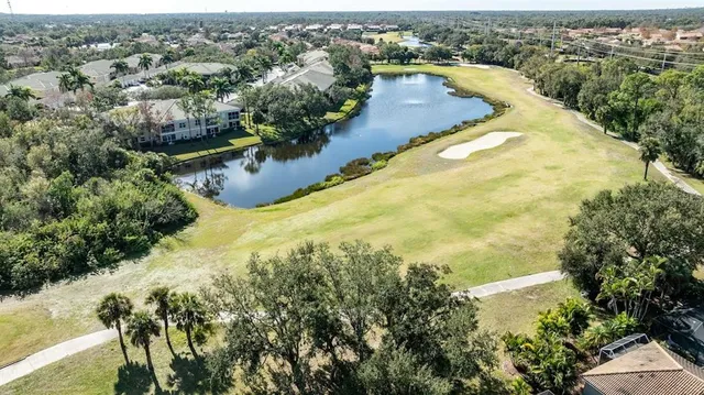an aerial view of residential house with outdoor space and a lake view in back