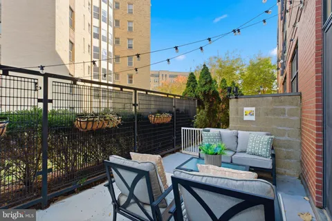 a view of a balcony with chairs and a potted plant