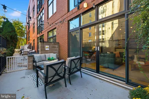 a view of a brick house with a chairs and table in the balcony