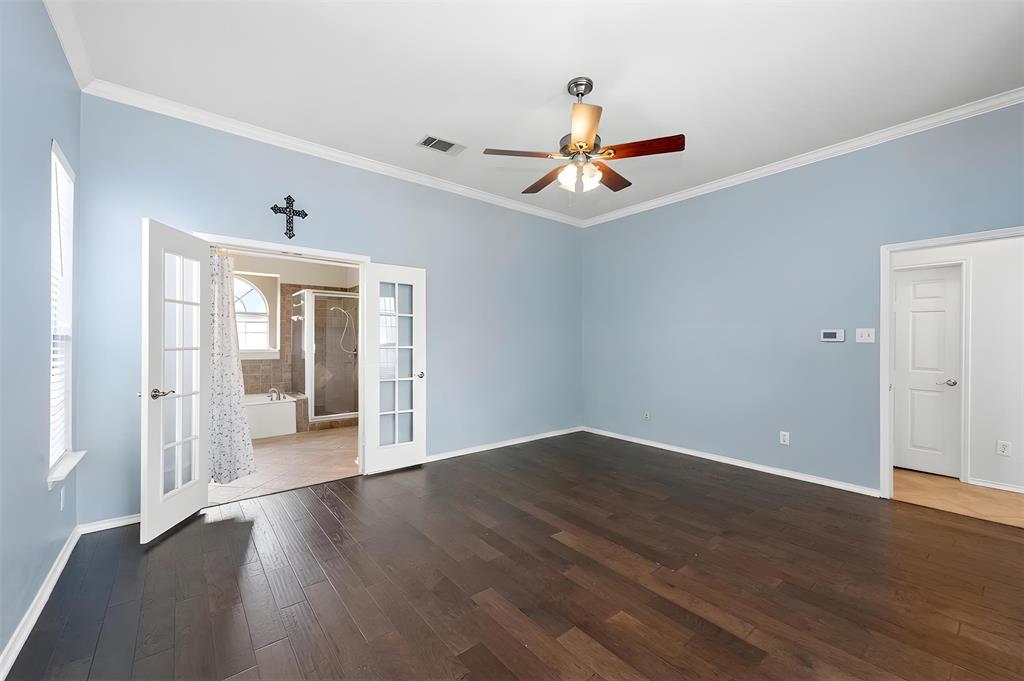 4202 Timberglen Road Dallas, TX 75287 - Photo 19 of 40 Spacious room featuring dark wood-finish flooring, vaulted ceilings with a ceiling fan, and crown molding