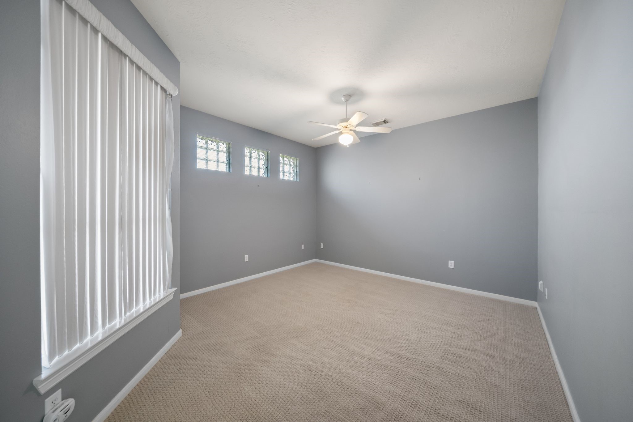 7 Sovereign Way Conroe, TX 77384 - Photo 14 of 31 en empty room with windows and chandelier fan