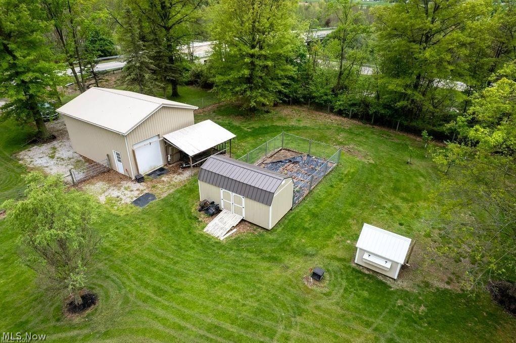 2530 Tuckahoe Road Wooster, OH 44691 - Photo 5 of 29 Expansive green lawn featuring a large detached outbuilding, a metal-roofed shed, and a fenced garden area