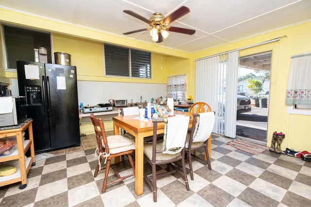a dining room with stainless steel appliances kitchen island granite countertop a dining table and chairs