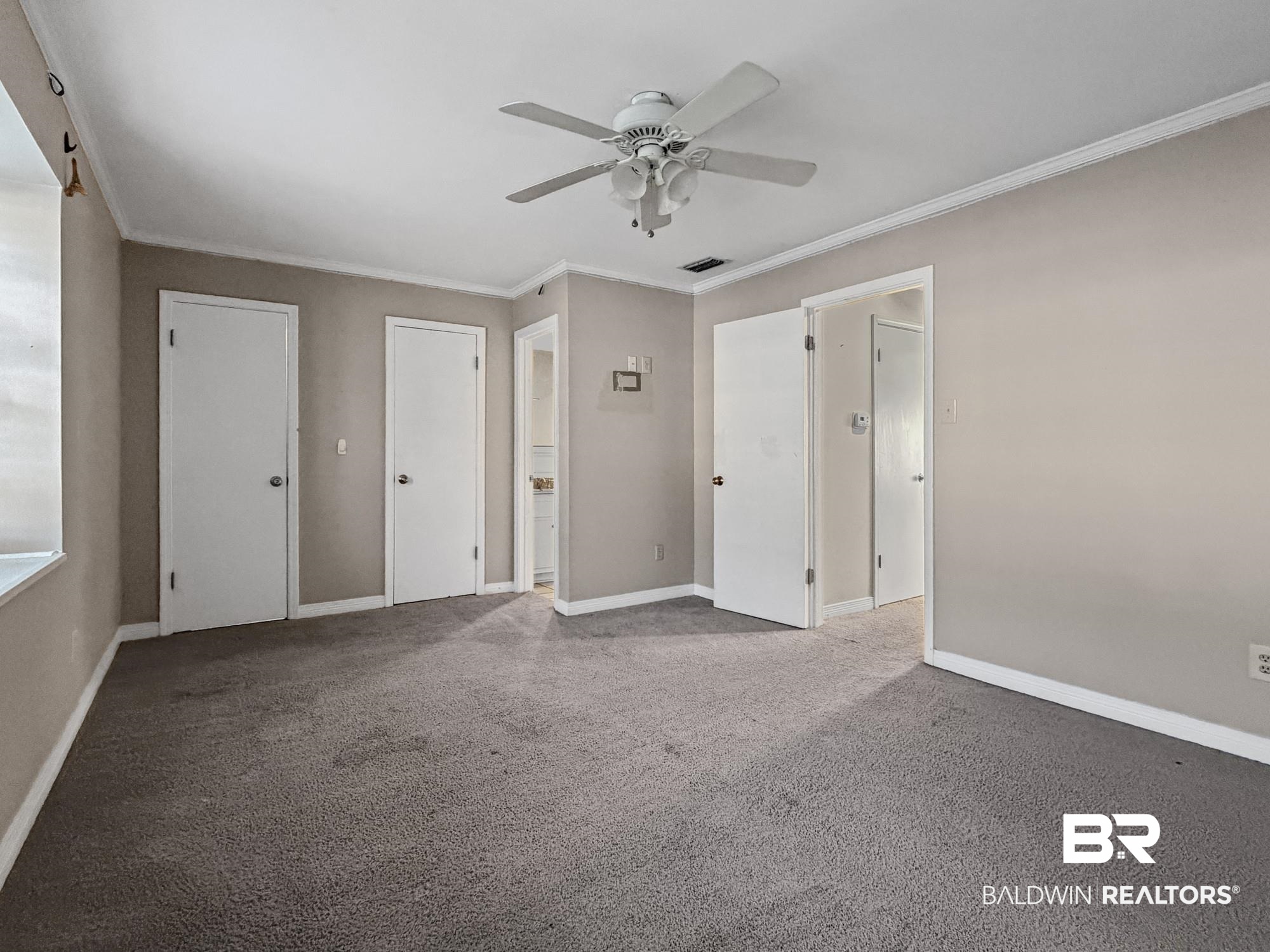 114 Du Rhu Drive, Unit A Mobile, AL 36608 - Photo 9 of 17 Spacious room featuring neutral wall tones, gray carpeting, and white crown molding