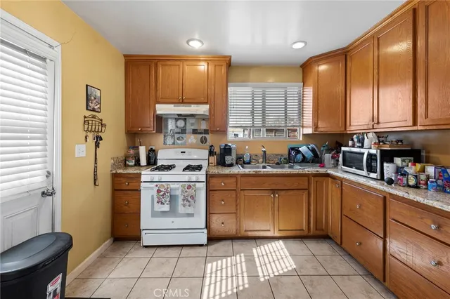 a kitchen with stainless steel appliances granite countertop a stove a sink and a refrigerator