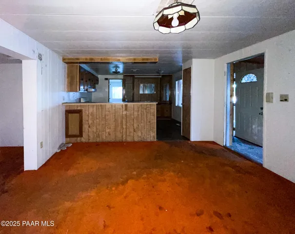 a view of an empty room with window and cabinet