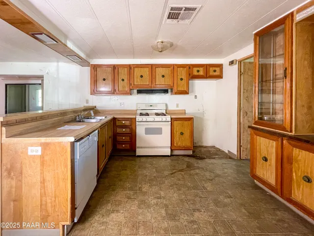 a kitchen with a stove sink and cabinets