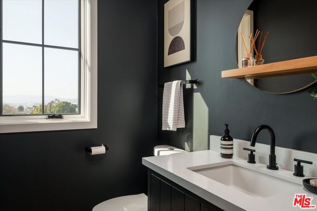 a bathroom with a sink vanity mirror and toilet
