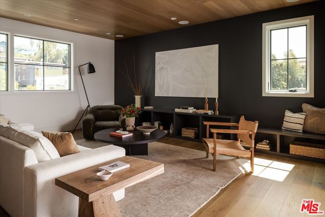 a living room with furniture a desk and chair with windows