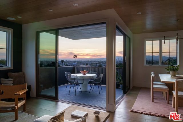 a living room with furniture a large window and a table