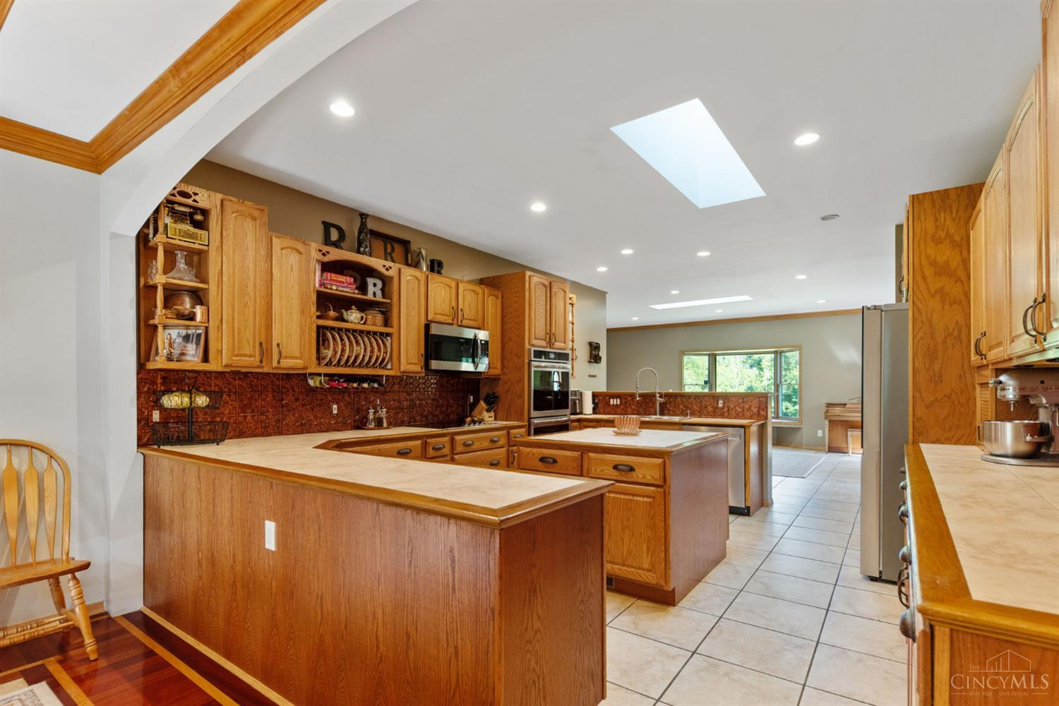 6050 Dry Ridge Road Cincinnati, OH 45252 - Photo 25 of 57 Expansive kitchen features an abundance of wood cabinetry, stainless steel appliances, skylight and center island.