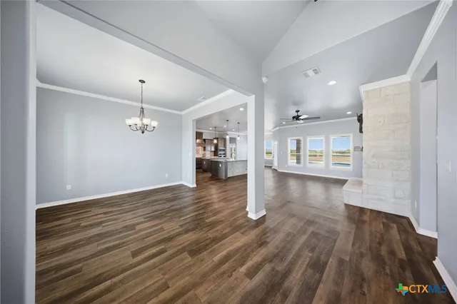 a kitchen with stainless steel appliances kitchen island granite countertop a refrigerator a oven a sink and white cabinets