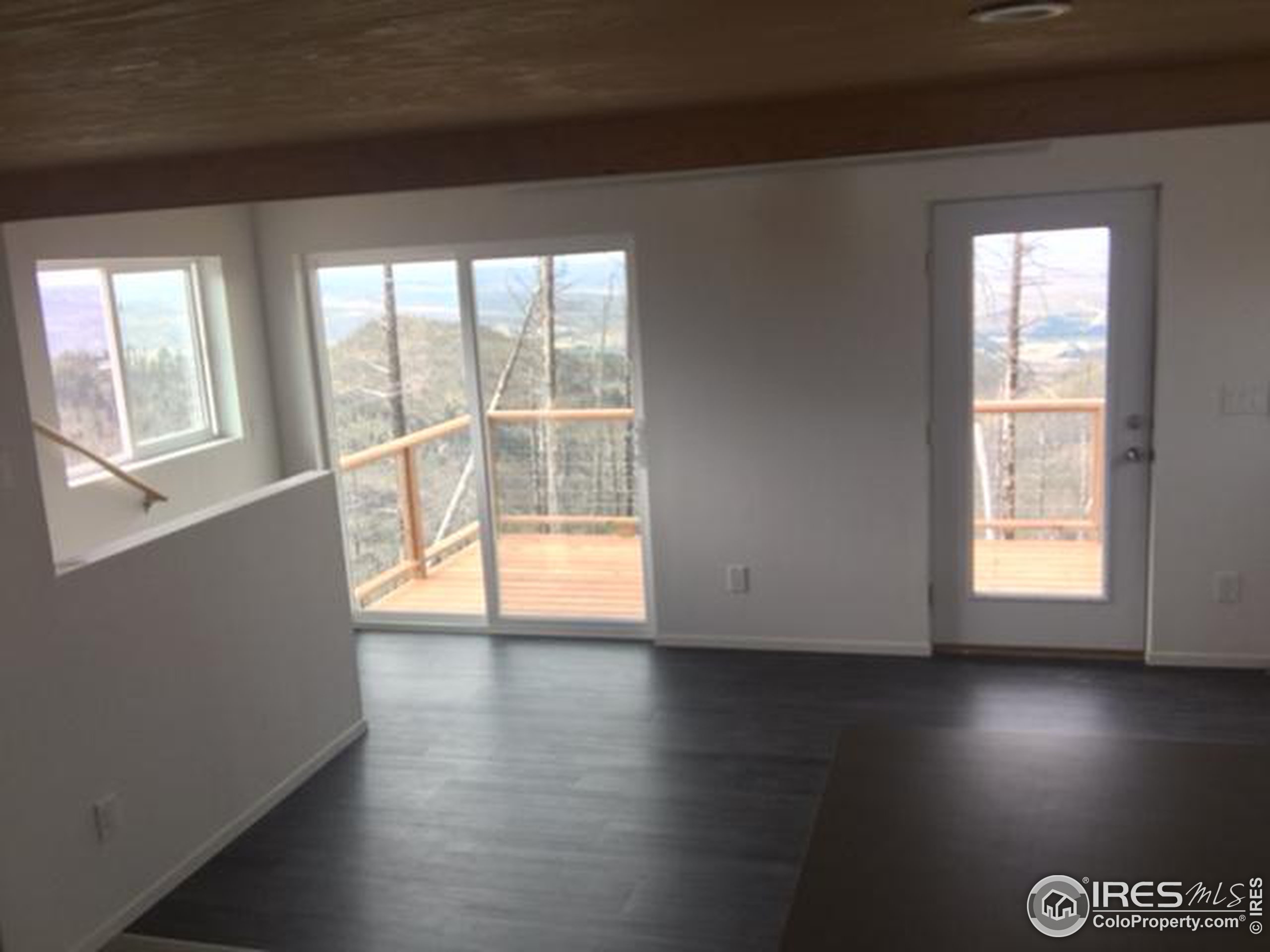 2518 Whale Rock Road Bellvue, CO 80512 - Photo 3 of 19 an empty room with wooden floor and windows