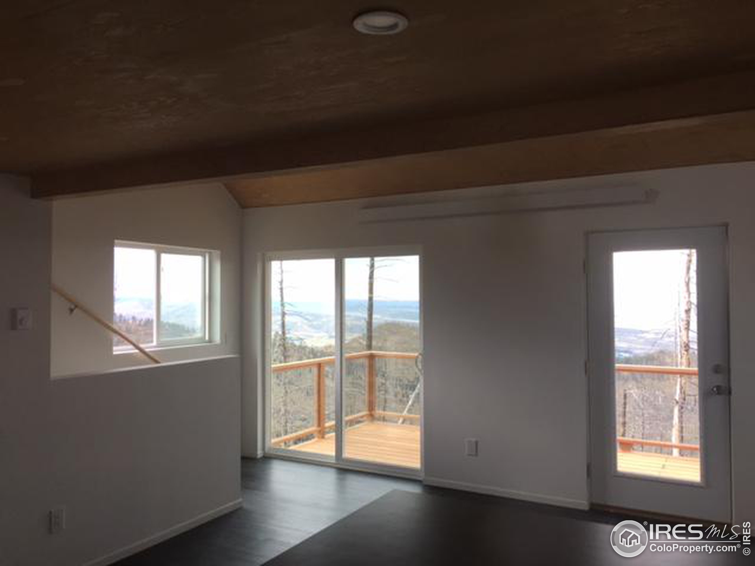 2518 Whale Rock Road Bellvue, CO 80512 - Photo 4 of 19 a view of an empty room with wooden floor and a window