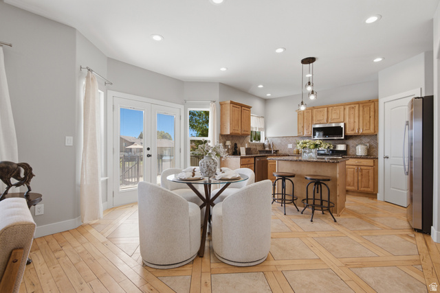 1252 Skyline Road Saratoga Springs, UT 84045 - Photo 13 of 51 Open-concept kitchen and dining area featuring light wood-finish flooring with tile accents, stainless steel appliances, a central island with a granite-style countertop, and recessed lighting