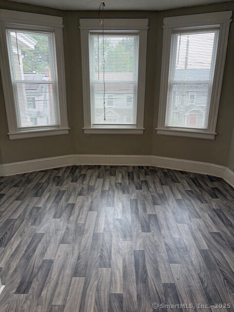 208 Fairview Avenue, Unit 2 Bridgeport, CT 06606 - Photo 7 of 11 an empty room with wooden floor and windows