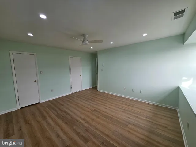 an empty room with wooden floor and entrance