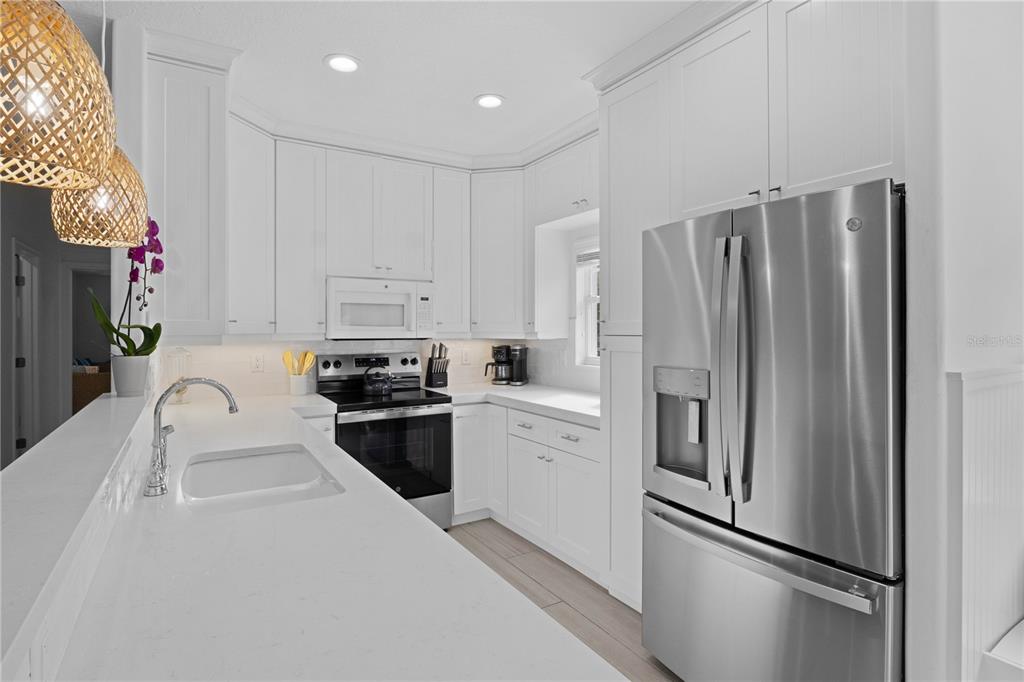 307 Spring Avenue Anna Maria, FL 34216 - Photo 12 of 51 a kitchen with stainless steel appliances granite countertop a refrigerator sink and stove