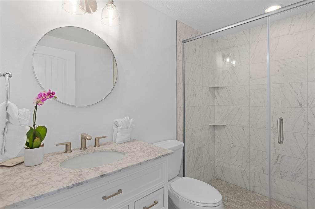 307 Spring Avenue Anna Maria, FL 34216 - Photo 24 of 51 a bathroom with a granite countertop sink a toilet and a mirror