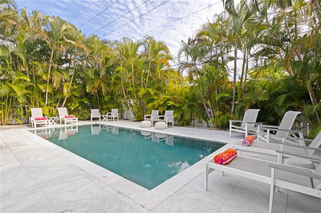 307 Spring Avenue Anna Maria, FL 34216 - Photo 37 of 51 a view of swimming pool with lounge chair and trees