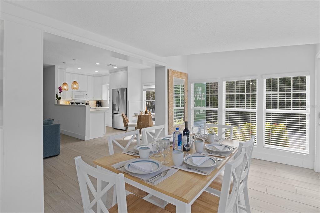 307 Spring Avenue Anna Maria, FL 34216 - Photo 4 of 51 a dining room with furniture and large windows