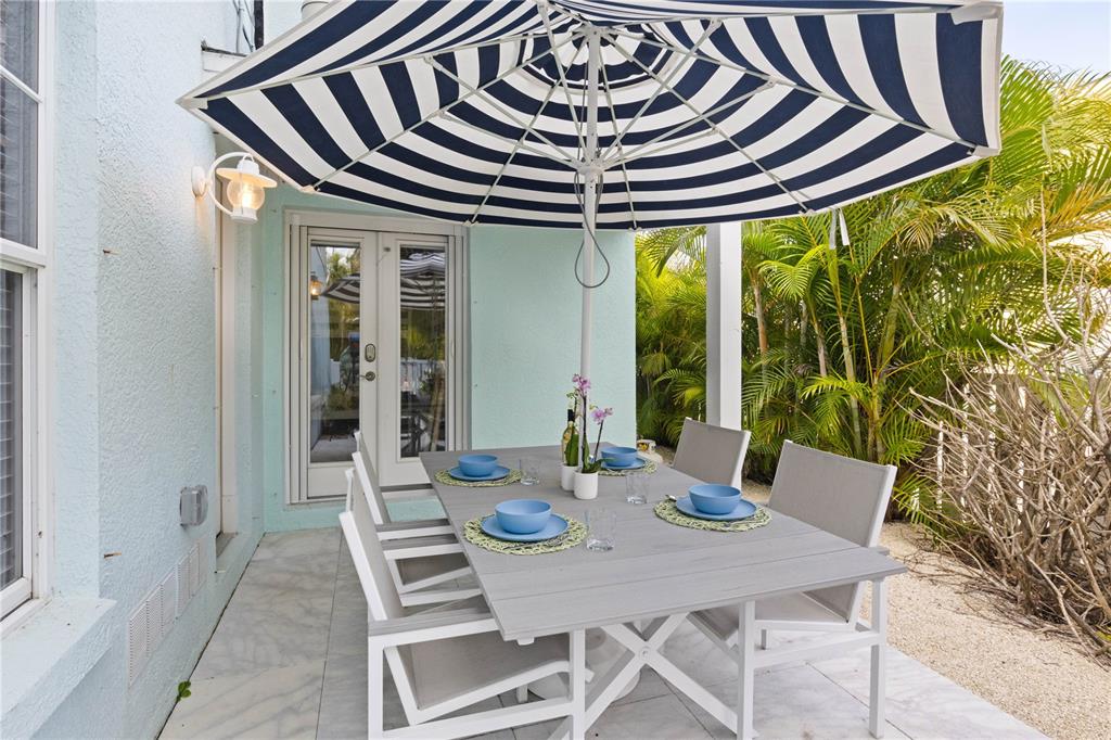 307 Spring Avenue Anna Maria, FL 34216 - Photo 42 of 51 a view of a dining table and chairs in the patio