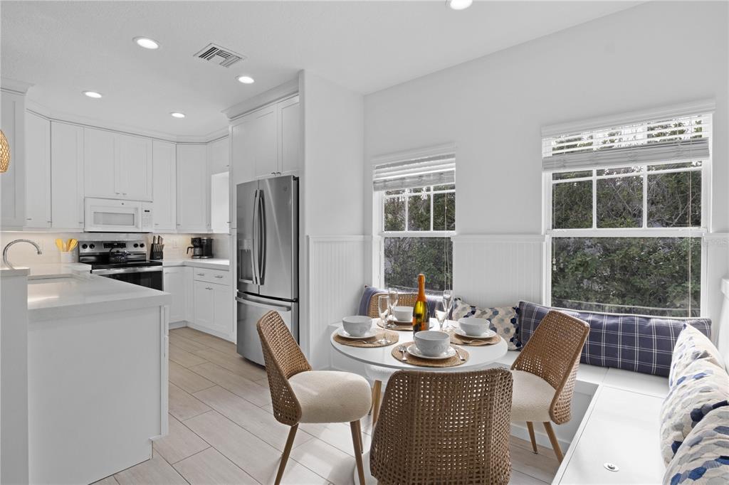 307 Spring Avenue Anna Maria, FL 34216 - Photo 10 of 51 a kitchen with stainless steel appliances granite countertop a refrigerator a stove a dining table and chairs