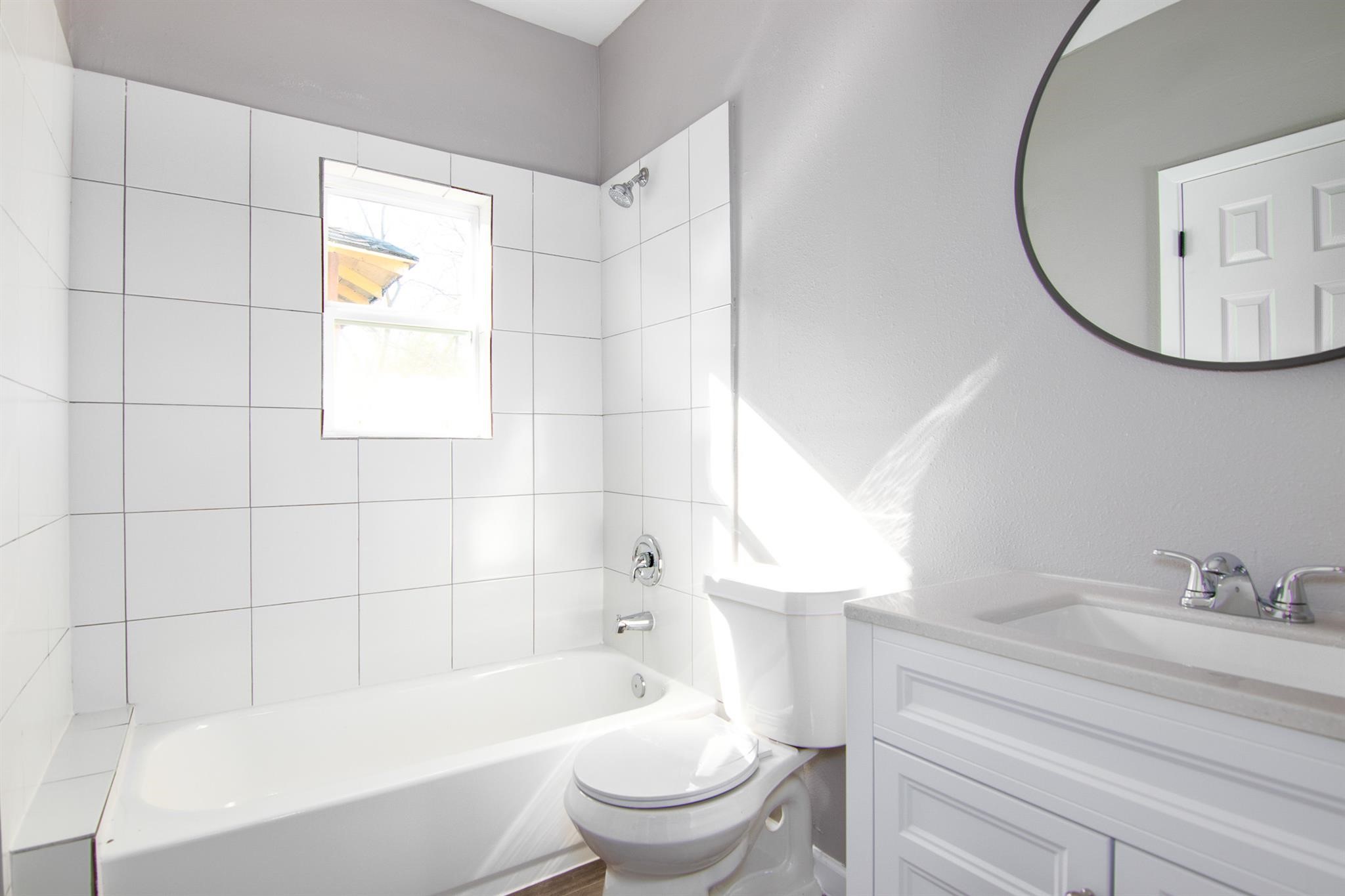 1709 Stevens Street Houston, TX 77026 - Photo 12 of 17 a bathroom with a bathtub a sink a toilet and a mirror