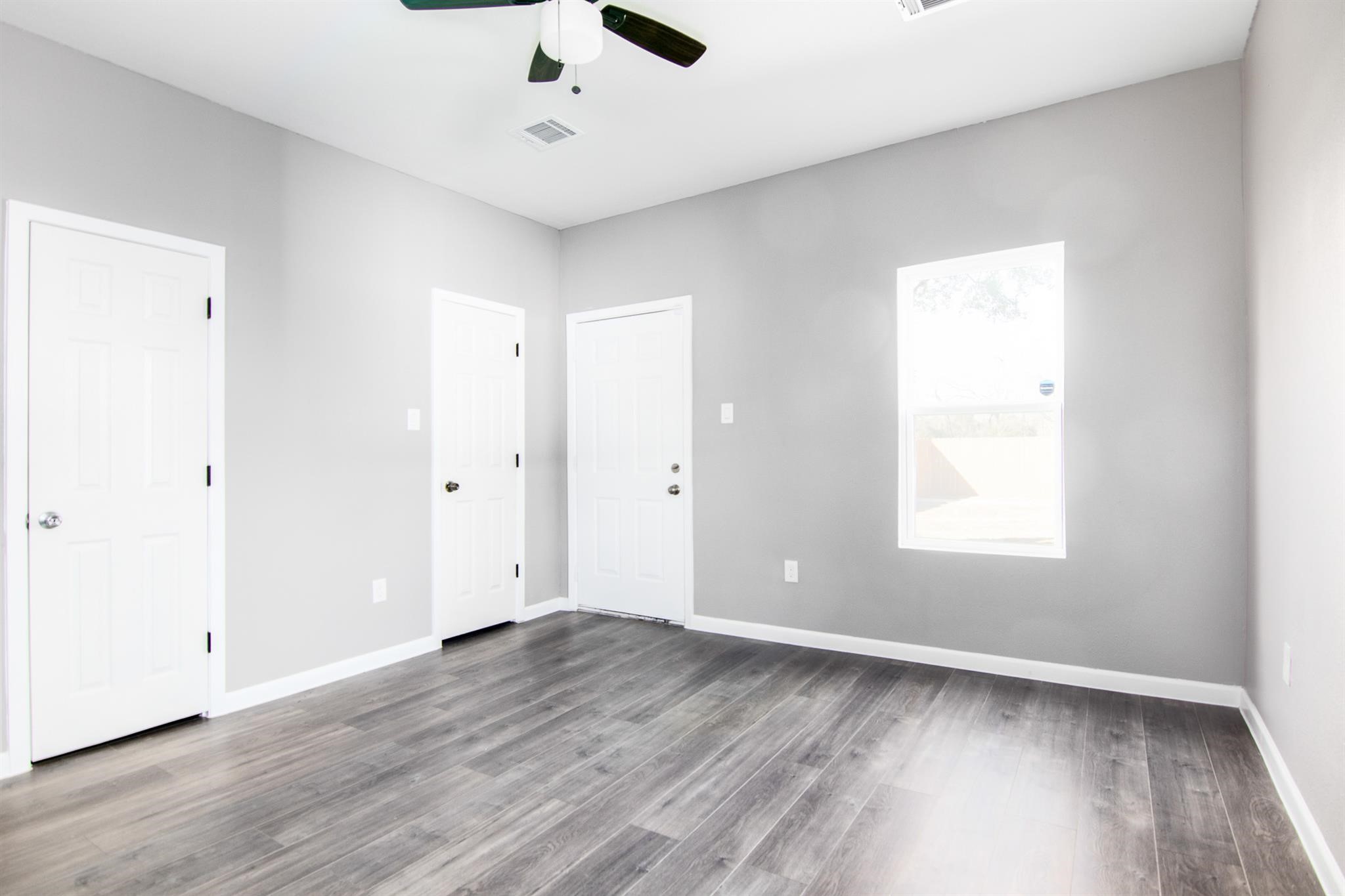 1709 Stevens Street Houston, TX 77026 - Photo 13 of 17 an empty room with wooden floor and windows