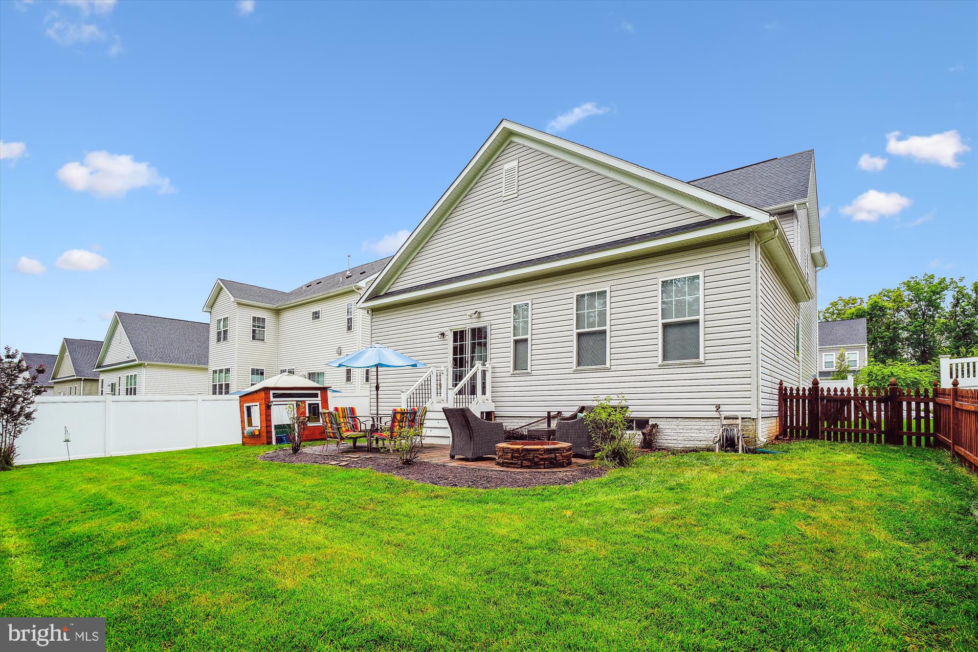 12141 Aster Road Bristow, VA 20136 - Photo 30 of 65 a view of a backyard with table and chairs potted plants and a palm tree