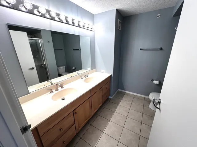 a bathroom with a granite countertop shower and a toilet