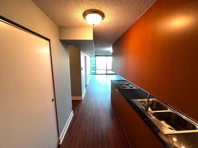 a view of a hallway with wooden floor