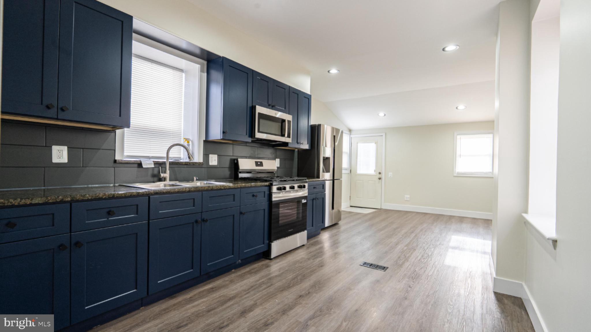 317 East Patapsco Avenue Baltimore, MD 21225 - Photo 21 of 36 Modern kitchen with sleek blue cabinetry.