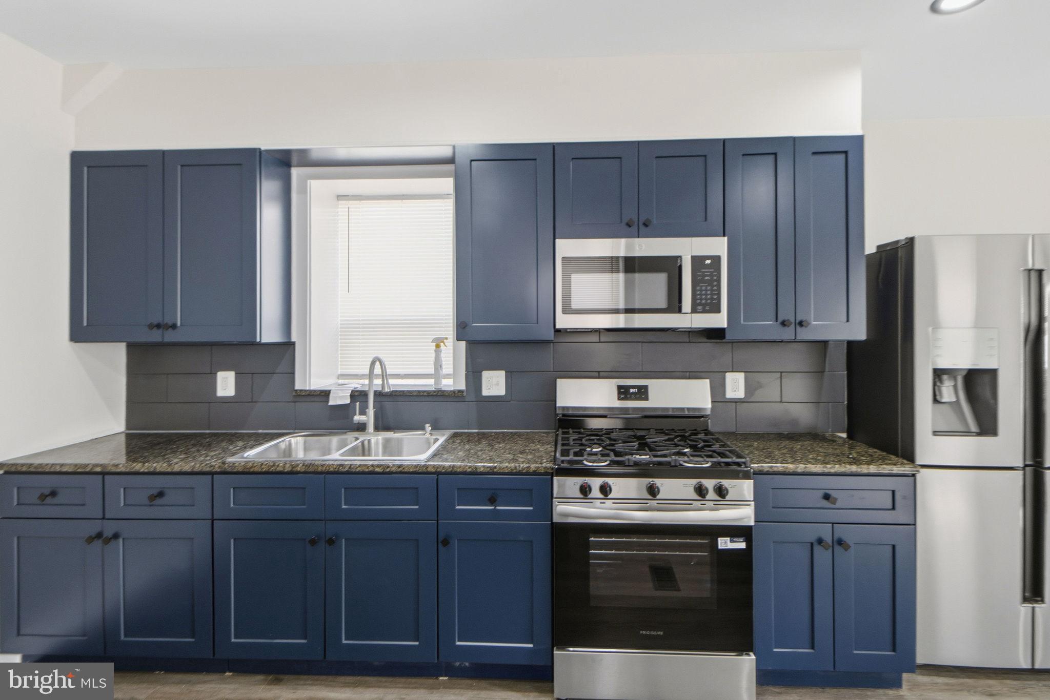 317 East Patapsco Avenue Baltimore, MD 21225 - Photo 23 of 36 Modern kitchen with sleek blue cabinetry.