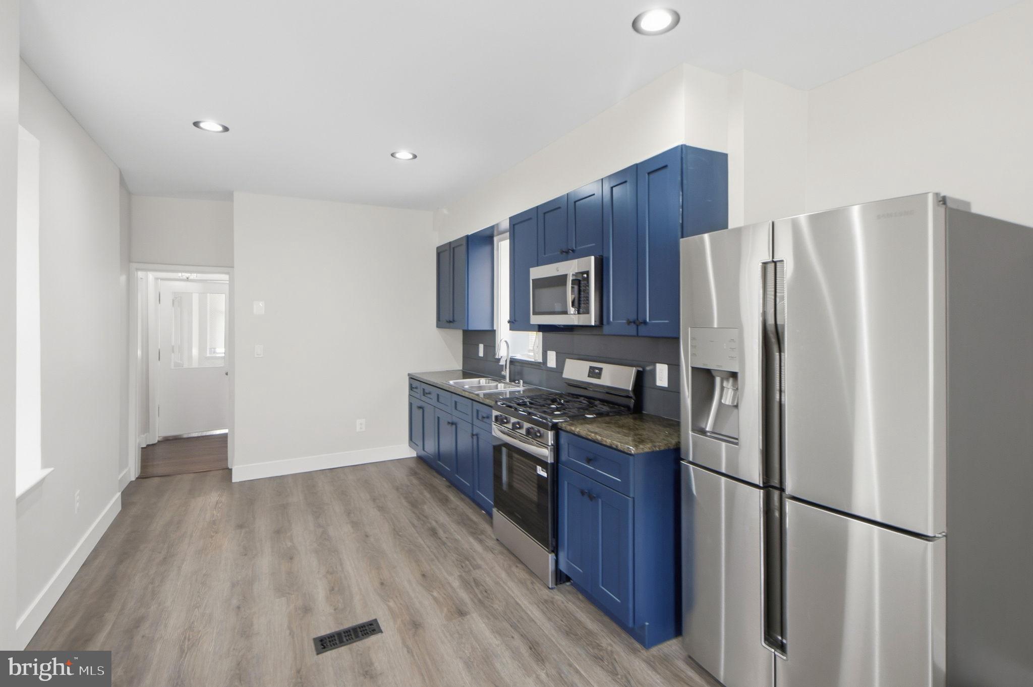 317 East Patapsco Avenue Baltimore, MD 21225 - Photo 24 of 36 Modern kitchen with sleek blue cabinetry.