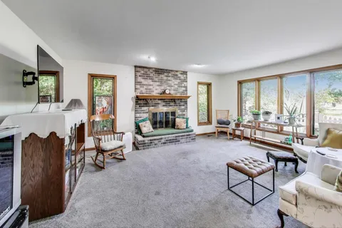 a living room with furniture large window and a fireplace