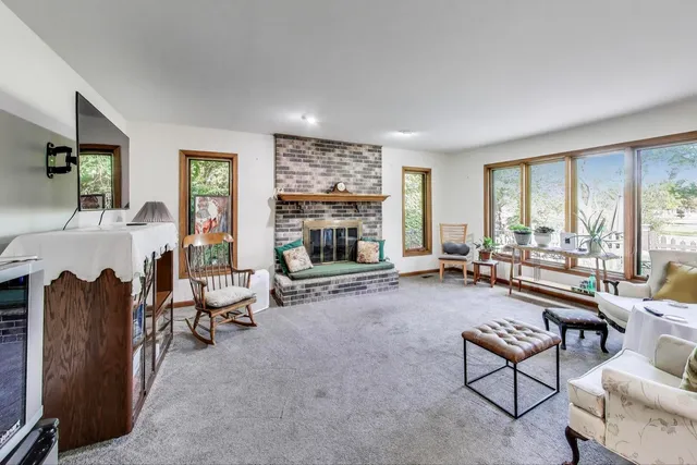 a living room with furniture large window and a fireplace