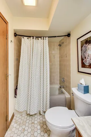 a white toilet sitting next to a bathroom sink and vanity