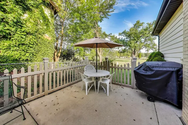 a view of a patio with a table and chairs under an umbrella