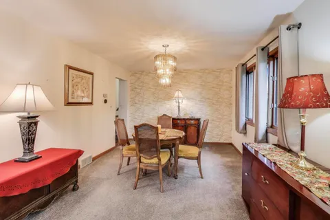 a view of a dining room with furniture and chandelier
