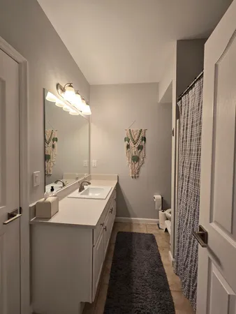 a bathroom with a sink a toilet a mirror and shower