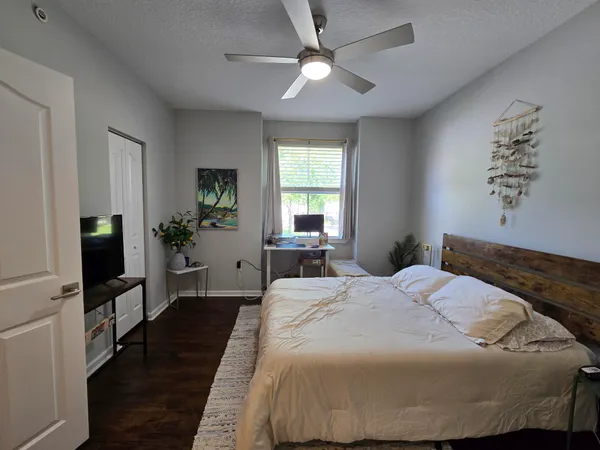 a bedroom with a bed and a flat tv screen on dresser