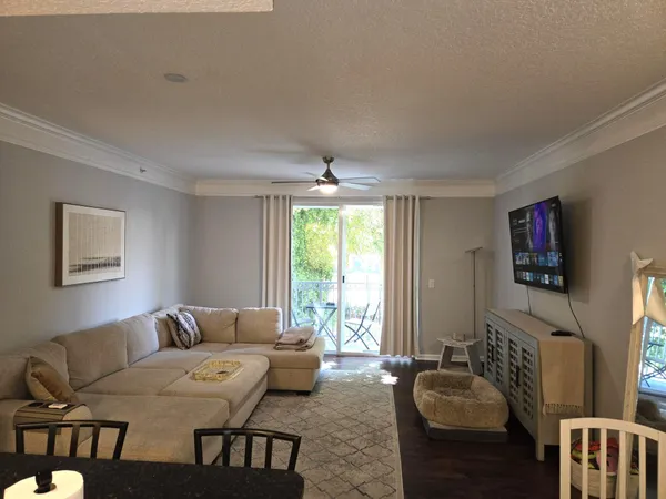 a living room with furniture a large window and a flat screen tv