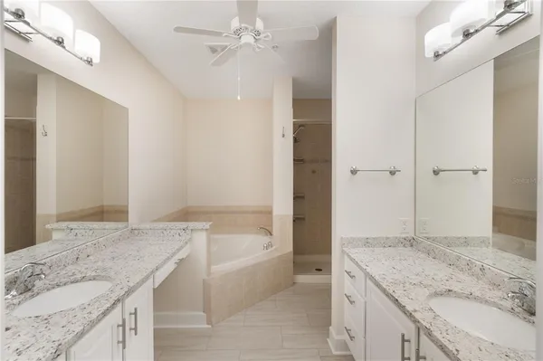 a bathroom with a granite countertop bathtub shower sink and mirror