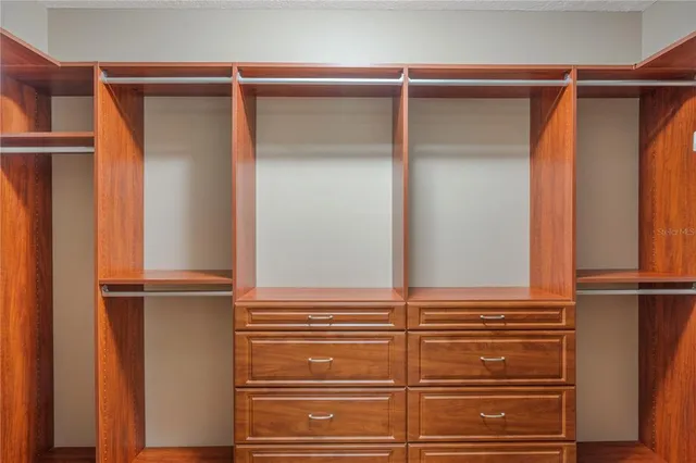a view of walk in closet with empty racks