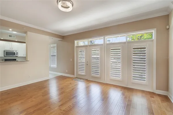 an empty room with wooden floor and windows