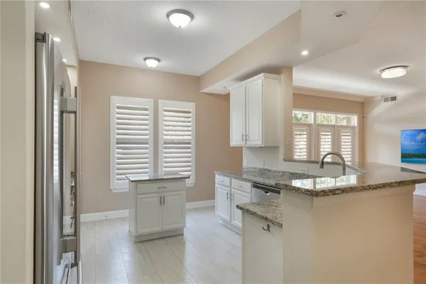 a kitchen with granite countertop a sink and white cabinets