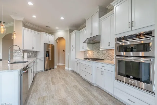 a large kitchen with stainless steel appliances granite countertop a stove a sink and a microwave