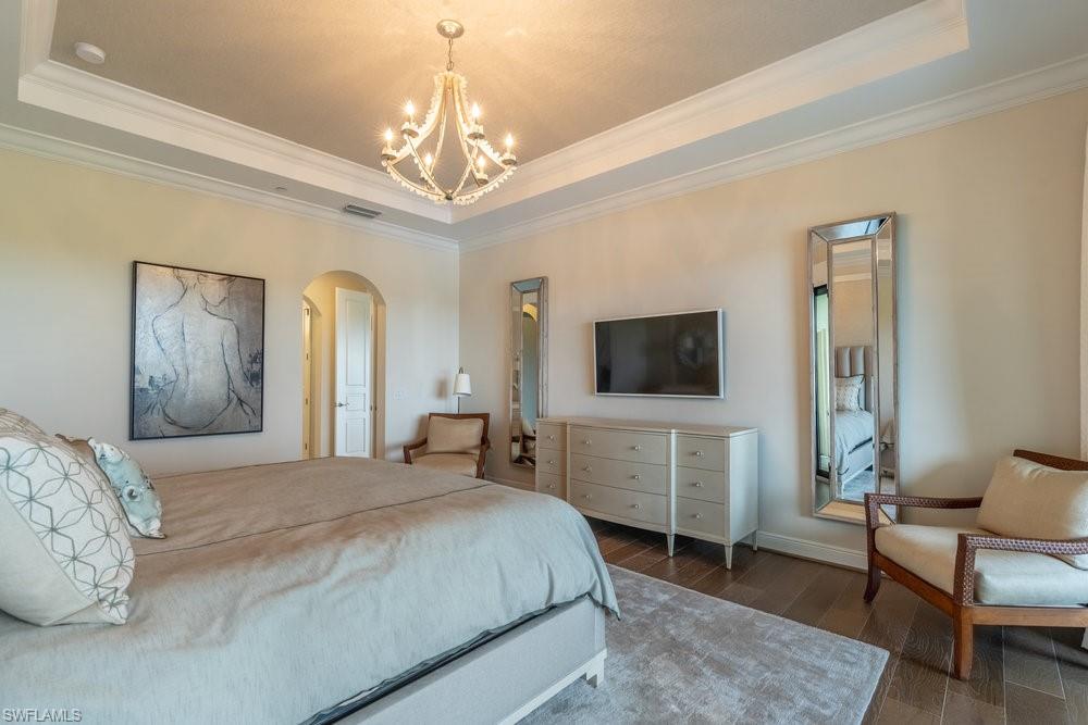 16444 Carrara Way, Unit 7301 Naples, FL 34110 - Photo 16 of 42 a bedroom with a bed and a flat screen tv